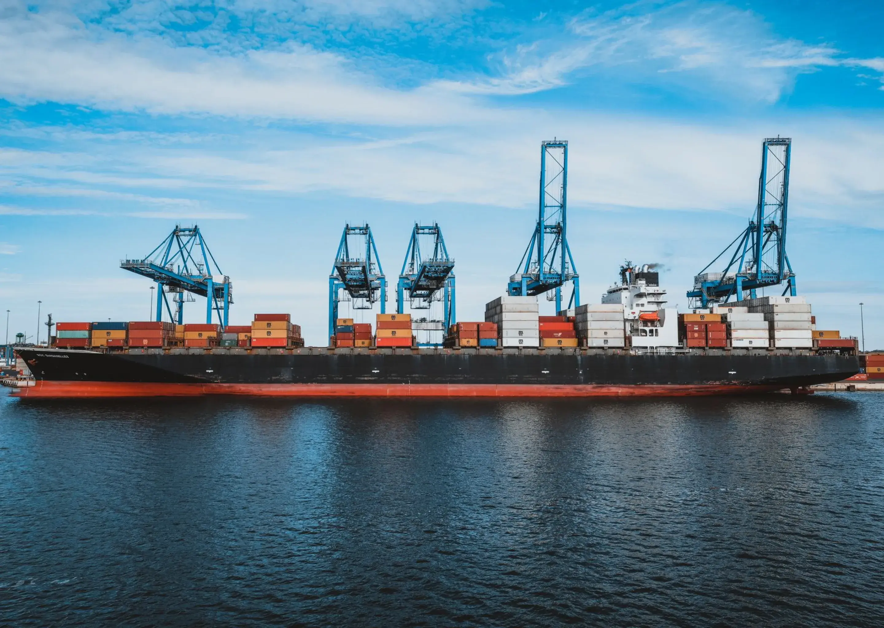 Container ship being loaded by gantry cranes at a port