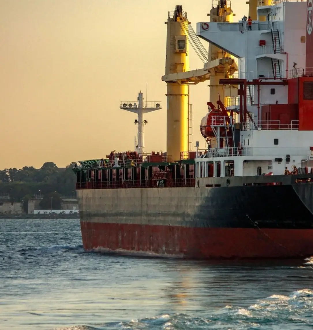 Cargo vessel under way at sunset for marine logistics